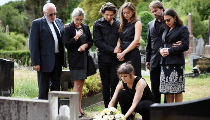 Family laying flowers on the grave Family laying flowers on the grave
